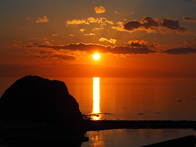 水面に反射する夕日の写真